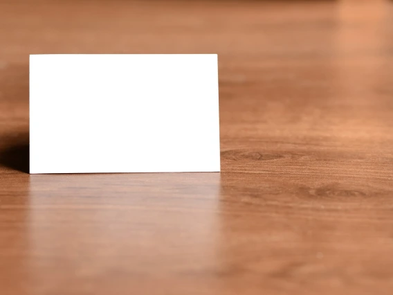 A blank white card against a woodgrain backdrop