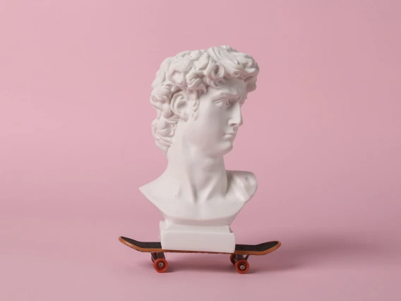 greek statue head on a toy skateboard