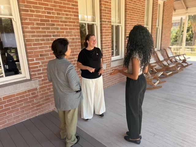 Jenna Rickus speaks with a student and a colleague outside of Old Main
