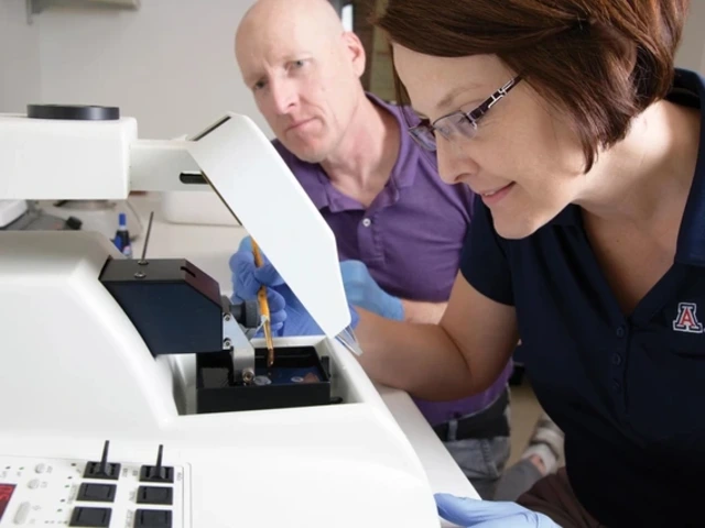 A man and a woman researcher analyze results over a white microscope.