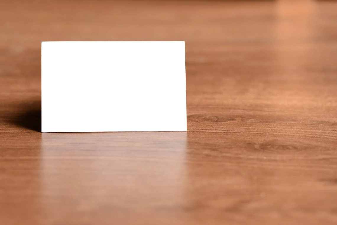 A blank white card against a woodgrain backdrop