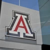 A large red, white and blue block 'A' is affixed to the side of a metal wall. The photo is taken through a window, casting a slight reflection.